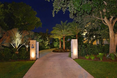 This is an example of a large tropical front yard driveway in Tampa with concrete pavers.