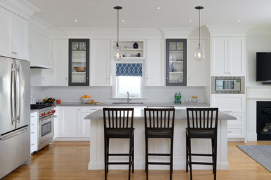 Open concept kitchen - mid-sized transitional l-shaped light wood floor open concept kitchen idea in Toronto with shaker cabinets, quartz countertops, white backsplash and stainless steel appliances