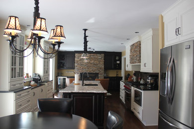 Example of a large dark wood floor eat-in kitchen design in New York with an undermount sink, beige cabinets, granite countertops, stainless steel appliances and an island