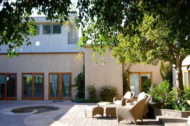 Example of a large trendy beige two-story stucco exterior home design in San Diego