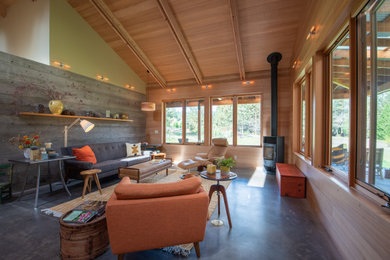 Inspiration for a rustic open concept concrete floor and gray floor living room remodel in Other with a wood stove and a metal fireplace