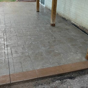 J-Stamped concrete patio with a step under the wood deck