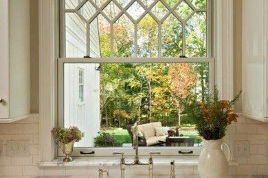 Mid-sized cottage l-shaped dark wood floor kitchen photo in Other with a farmhouse sink, shaker cabinets, white cabinets, quartz countertops, white backsplash and subway tile backsplash