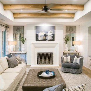 Inspiration for a large classic walk-out basement in Atlanta with white walls, light hardwood flooring, a standard fireplace, a concrete fireplace surround and brown floors.