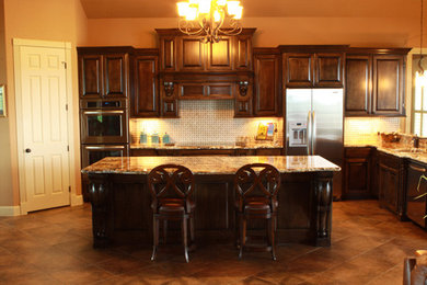 Inspiration for a large u-shaped ceramic tile open concept kitchen remodel in Houston with an undermount sink, dark wood cabinets, white backsplash, stainless steel appliances and an island