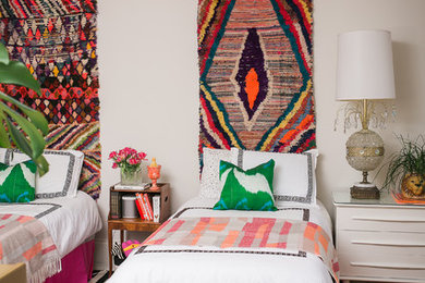 This is an example of an eclectic guest bedroom in Chicago with white walls, medium hardwood floors and no fireplace.