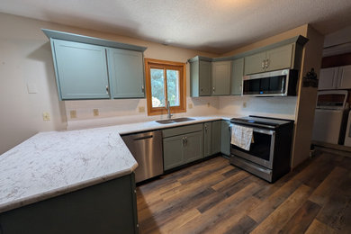 Example of a mid-sized transitional u-shaped eat-in kitchen design in Other with shaker cabinets, green cabinets, laminate countertops and white backsplash