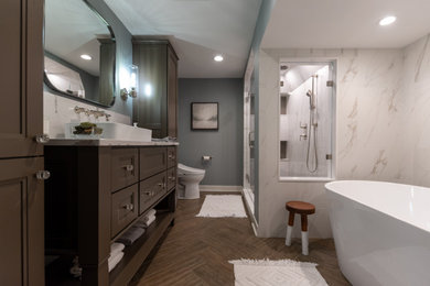 Freestanding bathtub - mid-sized transitional master white tile and porcelain tile porcelain tile, brown floor and single-sink freestanding bathtub idea in Chicago with flat-panel cabinets, white cabinets, blue walls, a vessel sink, quartz countertops, a hinged shower door, white countertops and a freestanding vanity