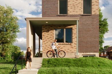 Design ideas for a mid-sized contemporary two-storey brick exterior in St Louis with a flat roof.