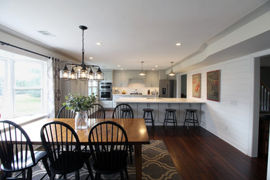 Inspiration for a large craftsman u-shaped dark wood floor and brown floor eat-in kitchen remodel in Philadelphia with a single-bowl sink, flat-panel cabinets, gray cabinets, quartzite countertops, white backsplash, subway tile backsplash, stainless steel appliances, a peninsula and gray countertops
