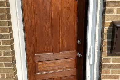 ミルウォーキーにある低価格の小さなトラディショナルスタイルのおしゃれな玄関ドア (白い壁、セラミックタイルの床、濃色木目調のドア、ベージュの床) の写真