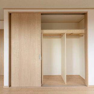 Esempio di una camera matrimoniale etnica con pareti bianche, pavimento in compensato, nessun camino e pavimento beige