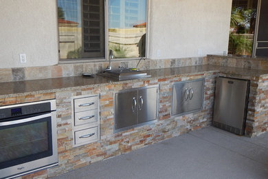 Eat-in kitchen - mid-sized southwestern l-shaped concrete floor eat-in kitchen idea in Phoenix with a single-bowl sink, granite countertops, multicolored backsplash, stone tile backsplash, stainless steel appliances and no island
