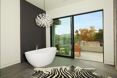 Large trendy master gray floor freestanding bathtub photo in Los Angeles with white walls