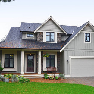 На фото: трехэтажный фасад дома зеленого цвета в классическом стиле с комбинированной облицовкой и двускатной крышей с