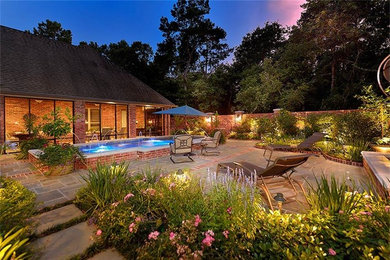 Inspiration for a large backyard patio in Houston with natural stone pavers and a water feature.