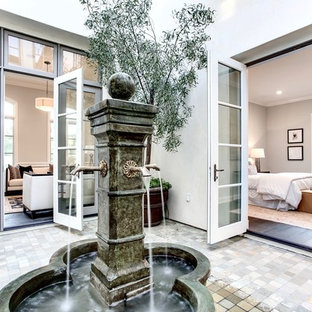 Exemple d'un jardin sur cour chic de taille moyenne avec un point d'eau, une exposition partiellement ombragée et des pavés en brique.