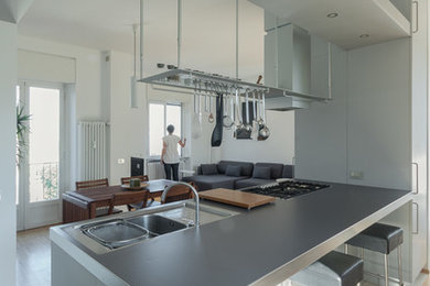 Idee per un cucina con isola centrale contemporaneo di medie dimensioni con lavello da incasso, ante lisce, ante grigie, top in laminato, elettrodomestici da incasso, pavimento in gres porcellanato e pavimento beige