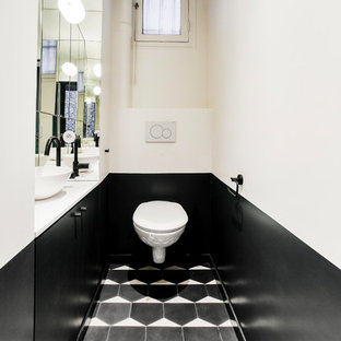 Idee per un bagno di servizio minimal di medie dimensioni con ante lisce, ante nere, WC sospeso, piastrelle bianche, piastrelle a specchio, pareti bianche, pavimento in cementine, lavabo a bacinella, top in quarzite, pavimento nero e top bianco