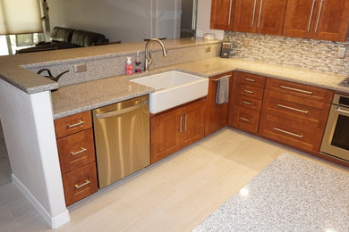 Inspiration for a large transitional u-shaped porcelain tile open concept kitchen remodel in Phoenix with a farmhouse sink, shaker cabinets, medium tone wood cabinets, granite countertops, multicolored backsplash, stainless steel appliances and an island