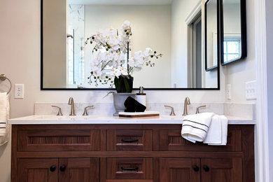 1960s master black and white tile and marble tile ceramic tile, white floor and double-sink corner shower photo in Boston with furniture-like cabinets, dark wood cabinets, a two-piece toilet, beige walls, an undermount sink, quartz countertops, a hinged shower door, white countertops, a niche and a built-in vanity