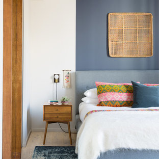 Imagen de dormitorio principal, retro, sin chimenea, con suelo de madera clara y paredes multicolor