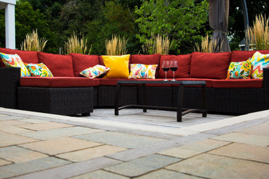 Design ideas for a mid-sized contemporary backyard patio in Toronto with natural stone pavers.