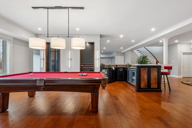 Seated home bar - large industrial l-shaped medium tone wood floor and brown floor seated home bar idea in Ottawa with an undermount sink, shaker cabinets, dark wood cabinets, quartz countertops, metal backsplash and white countertops