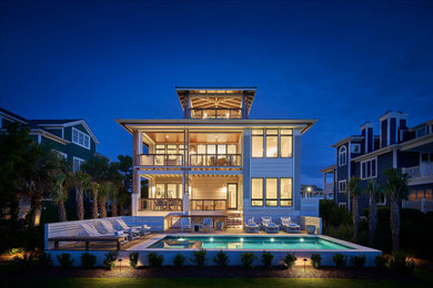 Large beach style four-story house exterior photo in Other with a metal roof
