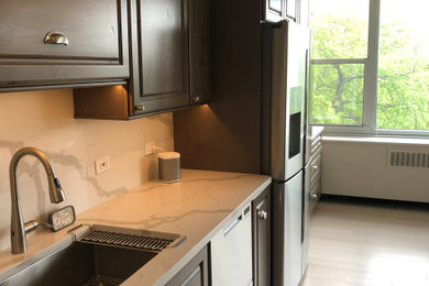 Mid-sized transitional galley light wood floor and beige floor eat-in kitchen photo in Chicago with an undermount sink, raised-panel cabinets, gray cabinets, quartz countertops, white backsplash, quartz backsplash, stainless steel appliances, no island and white countertops
