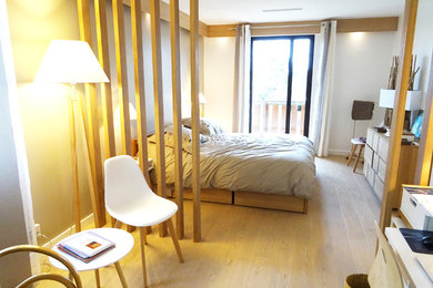 Inspiration for a mid-sized contemporary master bedroom in Lyon with white walls, light hardwood floors and beige floor.