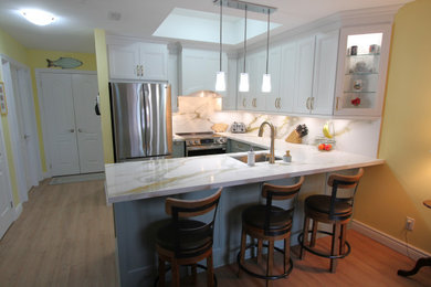 Inspiration for a small contemporary u-shaped vinyl floor and beige floor eat-in kitchen remodel in Toronto with an undermount sink, recessed-panel cabinets, white cabinets, quartz countertops, white backsplash, quartz backsplash, stainless steel appliances, a peninsula and white countertops