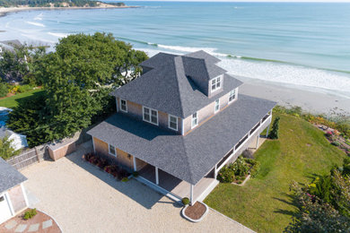 Large beach style multi-coloured house exterior in Boston with four or more storeys, wood siding, a hip roof, a shingle roof, a black roof and shingle siding.