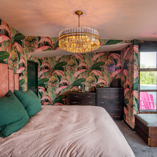 Esempio di una camera matrimoniale tropicale di medie dimensioni con pareti rosa, moquette, pavimento grigio e carta da parati