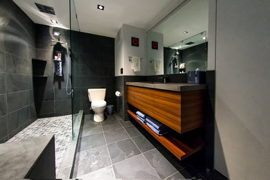 Mid-sized trendy master gray tile and slate tile gray floor bathroom photo in Chicago with flat-panel cabinets, medium tone wood cabinets, an undermount sink, concrete countertops, a two-piece toilet, gray walls and brown countertops