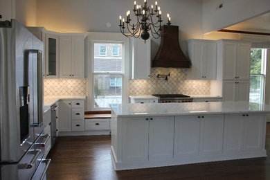 This is an example of a large eclectic u-shaped kitchen/diner in Raleigh with a belfast sink, flat-panel cabinets, white cabinets, granite worktops, white splashback, mosaic tiled splashback, stainless steel appliances, dark hardwood flooring, an island and white worktops.