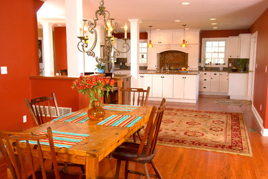 Large transitional u-shaped medium tone wood floor eat-in kitchen photo in New York with an undermount sink, recessed-panel cabinets, white cabinets, granite countertops, brown backsplash, porcelain backsplash, stainless steel appliances and two islands
