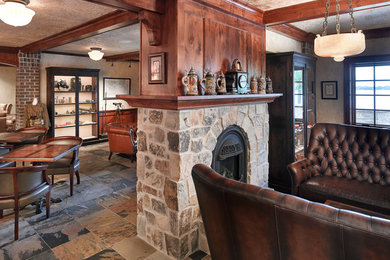 This is an example of a traditional home bar in Other with slate floors.