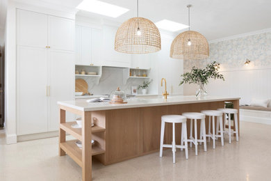 Photo of a country eat-in kitchen in Brisbane with shaker cabinets, quartz benchtops, white splashback, engineered quartz splashback, with island and white benchtop.