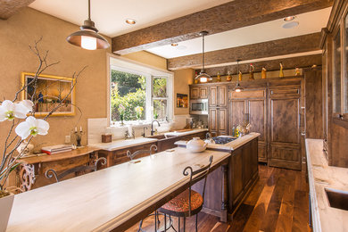 Inspiration for a large rustic u-shaped dark wood floor and brown floor kitchen pantry remodel in San Francisco with a farmhouse sink, raised-panel cabinets, dark wood cabinets, marble countertops, paneled appliances, an island, white backsplash and stone slab backsplash