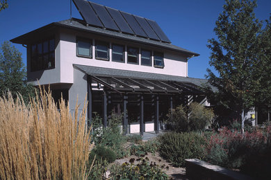 Example of a huge minimalist white two-story stucco exterior home design in Denver