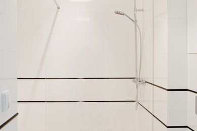 Example of a mid-sized eclectic master white tile and ceramic tile ceramic tile doorless shower design in Other with a console sink, flat-panel cabinets, white cabinets, laminate countertops, a wall-mount toilet and white walls