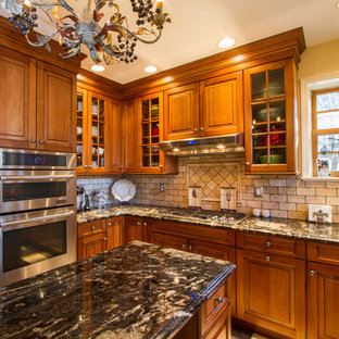 This is an example of a mid-sized traditional u-shaped kitchen pantry in St Louis with an undermount sink, raised-panel cabinets, medium wood cabinets, granite benchtops, multi-coloured splashback, travertine splashback, stainless steel appliances, ceramic floors, with island, multi-coloured floor and multi-coloured benchtop.