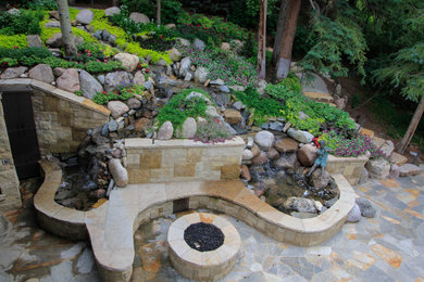 Inspiration for a backyard stone landscaping in Denver with a fire pit.