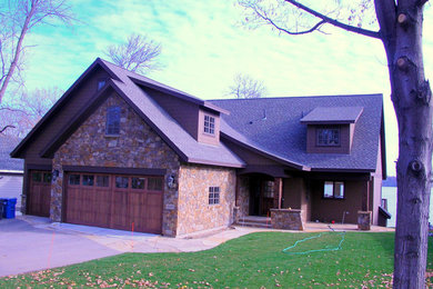 Photo of a large traditional two-storey beige exterior in Minneapolis with stone veneer.