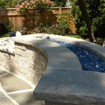 Custom built fire feature with blue glass inset set in stone wall