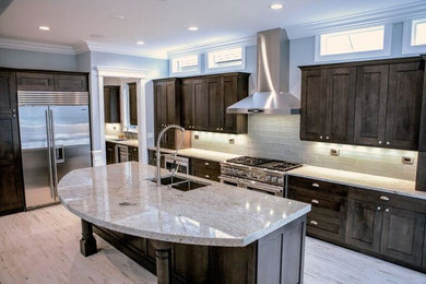 Inspiration for a mid-sized transitional u-shaped gray floor and light wood floor enclosed kitchen remodel in Chicago with a double-bowl sink, shaker cabinets, dark wood cabinets, granite countertops, gray backsplash, glass tile backsplash, stainless steel appliances and an island