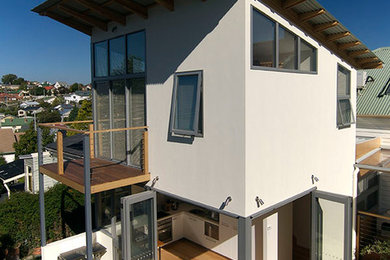 Photo of a small contemporary two-storey stucco white exterior in Hobart.