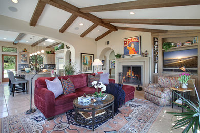 Photo of a large traditional open concept living room in Orange County with beige walls, travertine floors, a standard fireplace, a stone fireplace surround and a built-in media wall.