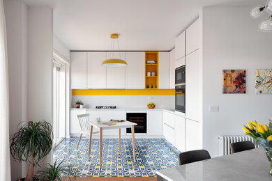 Foto de cocina actual abierta sin isla con salpicadero amarillo, suelo de baldosas de cerámica y suelo multicolor